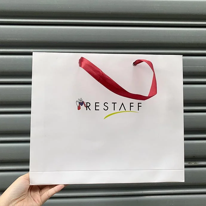 Túi giấy trắng in logo Restaff – quai ruy băng đỏ sang trọng, cao cấp